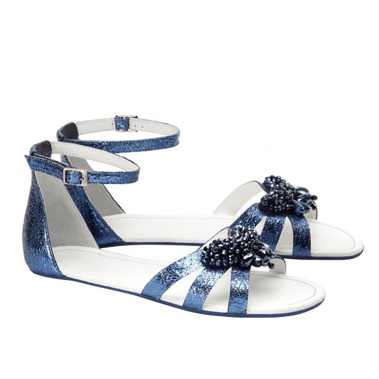 Entdecken Sie den eleganten Stil und Komfort der ZAQQ QISELLE Blue Sandalen. Diese atemberaubenden blauen Sandalen sind mit Knöchelriemen und einem Perlenbesatz auf der Vorderseite gestaltet, gepaart mit einer flachen Sohle mit metallischem Finish. Perfekt für alle, die die Ästhetik eleganter Barfußsandalen lieben.