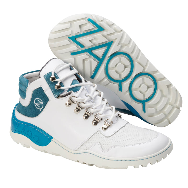 Erleben Sie die wasserfesten VAQATION Turquoise Sneakers von ZAQQ, die für stilvolle Abenteuer in der Stadt und im Freien konzipiert wurden. Diese High-Top-Sneaker sind vom Barfußschuh-Design inspiriert und verfügen über einen perforierten weißen Korpus mit blaugrünen Akzenten an Ferse und Zunge. Das unverwechselbare Profilmuster mit ZAQQ-Branding auf der Sohle sorgt dafür, dass Sie für Ihr nächstes Abenteuer bereit sind.