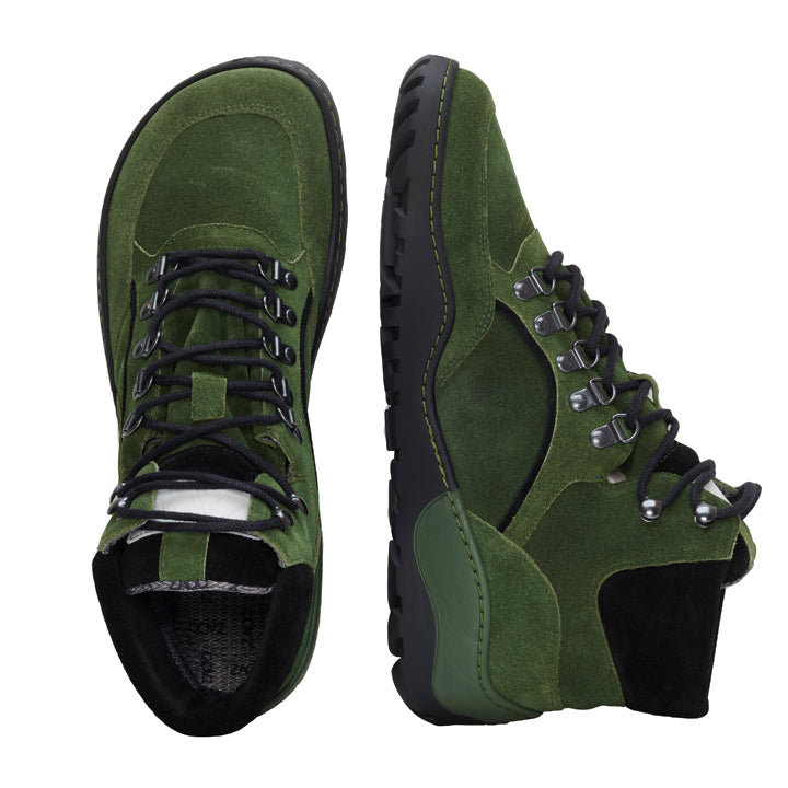 Ein Paar TREQ Green Waterproof Wanderstiefel von ZAQQ mit schwarzen Schnürsenkeln und einer robusten TERRA-Sohle. Ein Stiefel steht aufrecht, während der andere auf der Seite liegt. Dadurch sind die raffinierte Schnürung und das robuste Profil perfekt für Outdoor-Abenteuer.