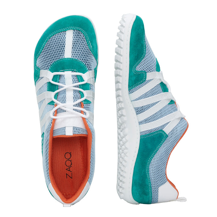 Die RIQ Turquoise Schuhe von ZAQQ sind ein Paar blaugrüne und weiße Sportschuhe aus Mesh-Gewebe und Gummisohlen, die für hervorragende Atmungsaktivität sorgen. Sie verfügen über ein orangefarbenes Innenfutter und sind mit weißen Schnürsenkeln ausgestattet. Ein Schuh ist von oben zu sehen, während der andere, der einem Barfußschuh ähnelt, von der Seite zu sehen ist.