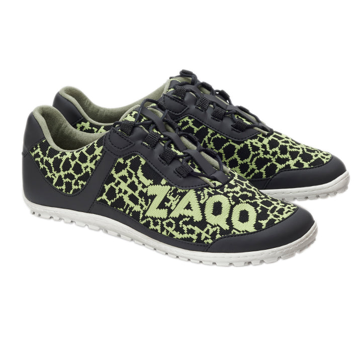 Die QINGSTON Green Sneaker von ZAQQ zeigen neongrüne geometrische Muster mit der Nummer 2400 auf der Seite, auf einem eleganten schwarzen Hintergrund. Sie verfügen über weiße Sohlen und schwarze Schnürsenkel, alle aus veganen Materialien gefertigt, und bieten ein unverwechselbares Design, das sich deutlich von einem strahlend weißen Hintergrund abhebt.