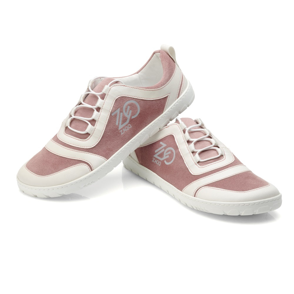 Ein Paar stylische SQILL Rose Sneaker in Pink und Weiß mit weichem veganem Mikrofaser-Finish und Ziernähten. Diese Sneaker haben ein Schnürdesign und zeigen das ZAQQ-Markenlogo an der Seite auf einer glänzenden weißen Oberfläche.