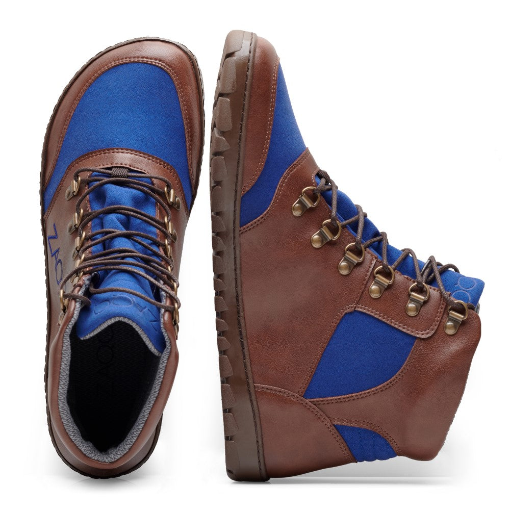 Die HIQE Brown Blue Waterproof Stiefel von ZAQQ bestehen aus braunem Leder und blauen Stoffeinsätzen sowie einer flexiblen Kautschuksohle. Ein Stiefel steht aufrecht, während der andere auf der Seite liegt, wodurch die Sohlen und Schnürdetails hervorgehoben werden.