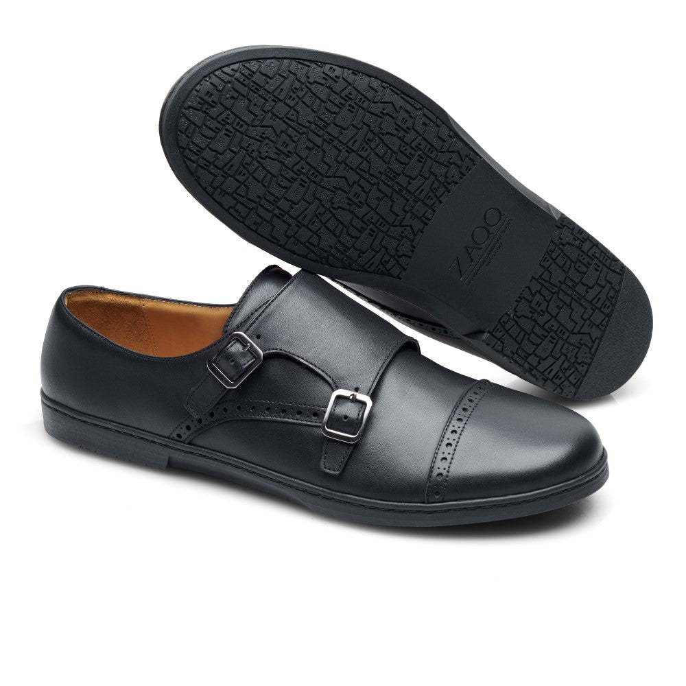 Die MONQ Captoe Black Schuhe von ZAQQ strahlen Eleganz aus mit ihrem schwarzen Leder-Monkstrap-Design mit Doppelschnallen. Ein Schuh steht aufrecht, um sein schlankes Seitenprofil hervorzuheben, während der andere mit der Sohle nach oben liegt und seinen strukturierten Griff und die Barfußsohle mit dem Markennamen ZAQQ präsentiert. Sie sind perfekt, um Ihre Businessschuh-Kollektion neu zu definieren.