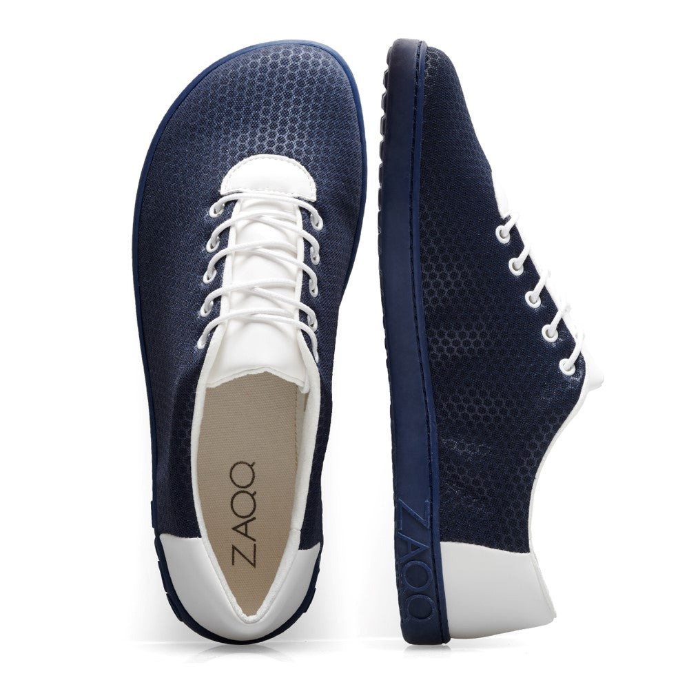 Ein Paar QARO Mare Sneaker von ZAQQ in Marineblau, aus veganen Materialien, mit weißen Schnürsenkeln und Sohlen. Der linke Schuh ist von oben zu sehen, der rechte Schuh von der Seite. Das langlebige Kautschuk-Logo von ZAQQ ziert die Seite und verleiht sowohl Stil als auch umweltfreundlichen Charme.