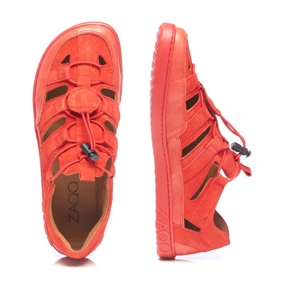 Ein Paar QLEAR Red Sneaker-Sandalen in leuchtendem Orange ist sowohl von der Seite als auch von oben zu sehen. Die Schuhe haben ein gewebtes Design mit verstellbaren Schnürsenkeln und einer dicken Sohle, was sie ideal als Sommer-Outdoorschuhe macht. Der Markenname ZAQQ ist deutlich auf der Seite der Sohle zu sehen.